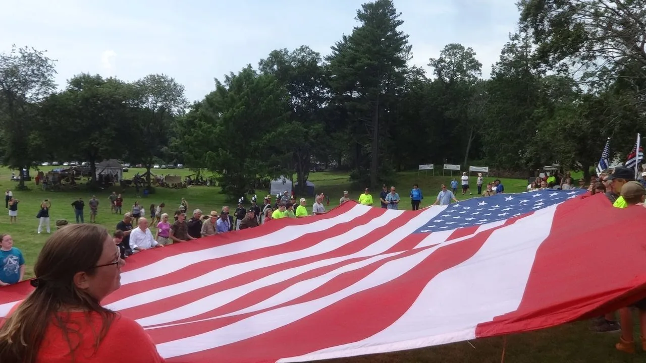 Community members carrying the American flag in remembrance