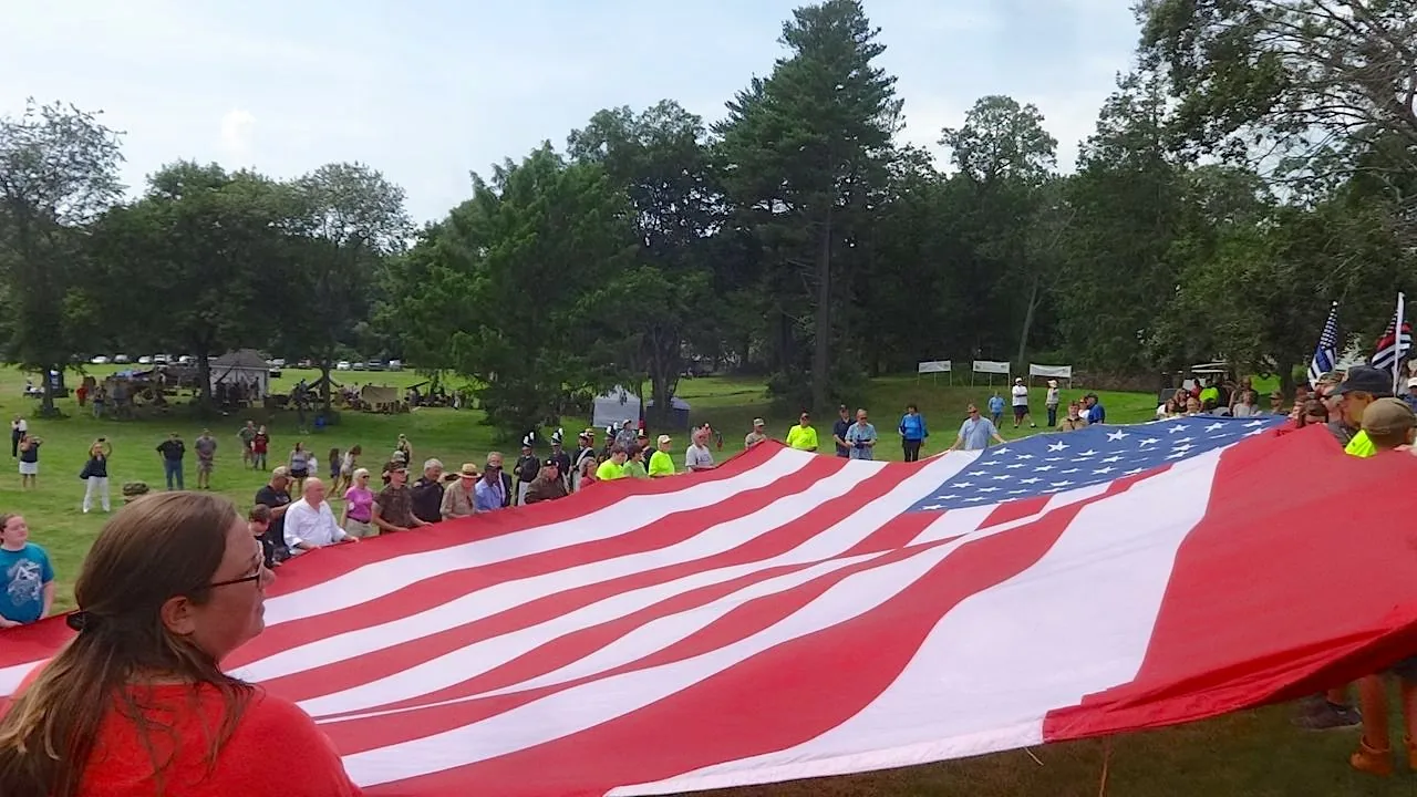 Community members carrying a large American flag at Military Service Day